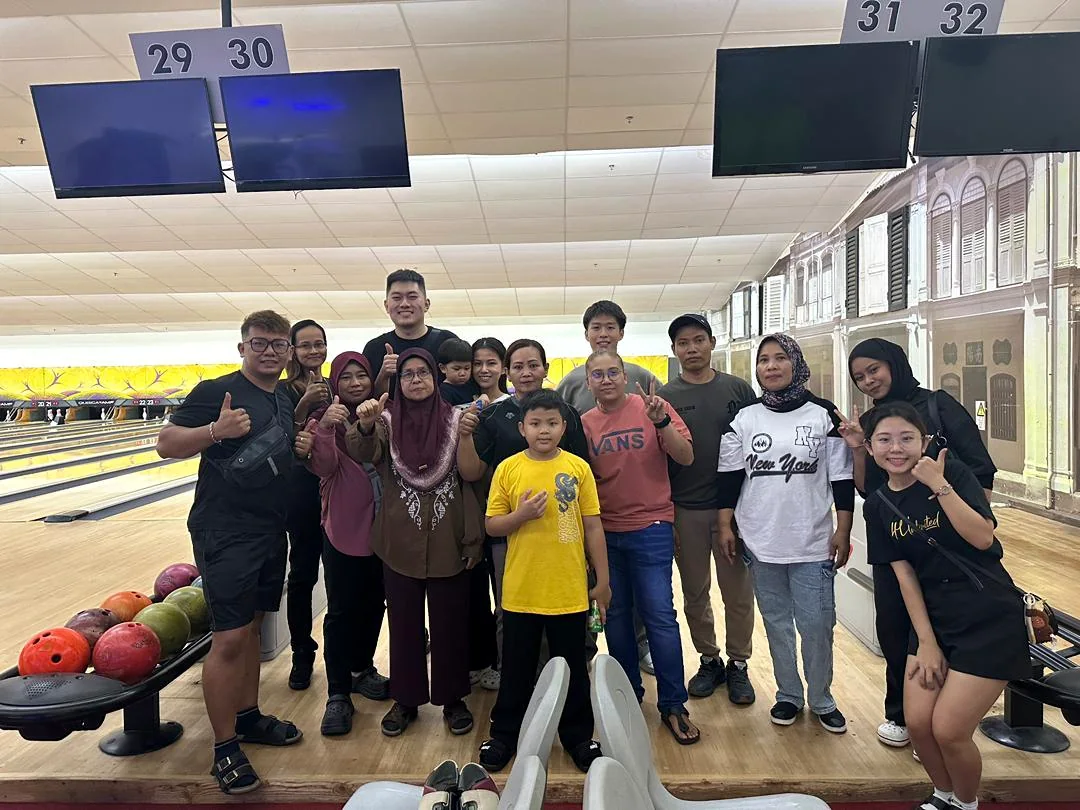 Adults and children attending a Reno Rent Manage bowling activity in Penang